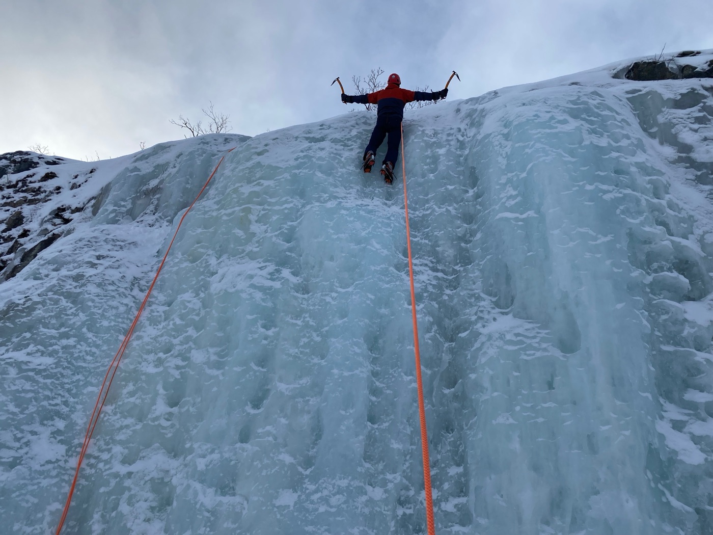 Arvind ice climbing a frozen waterfall above the Arctic Circle in Sweden.